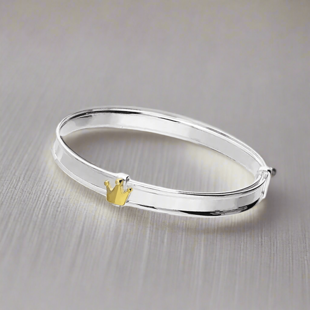 Sterling silver baby bangle with enamel daisy, heart, or crown. Expandable, engravable, perfect keepsake.